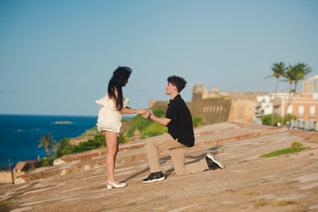 Man proposing on one knee during sunset in Old San Juan Puerto Rico with ocean view